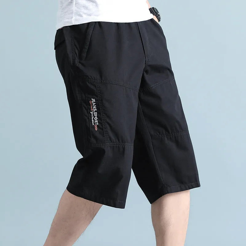 Man wearing loose grey cotton sports pants with a straight leg and cropped length.