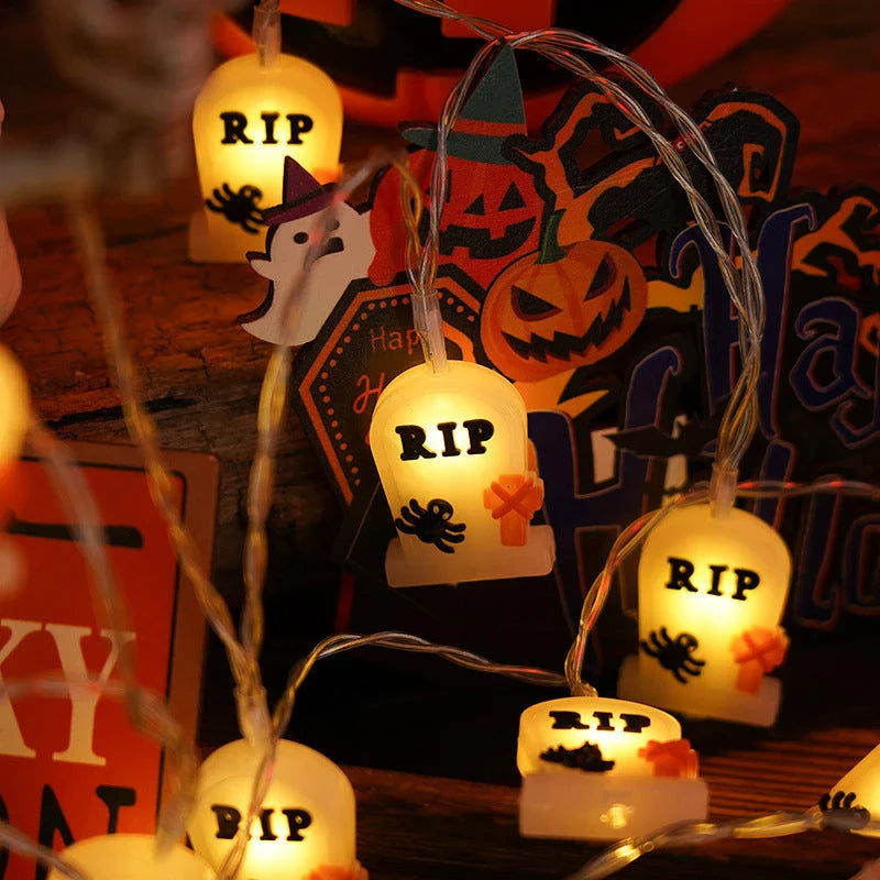 Battery-powered LED Halloween lights in various spooky designs including pumpkins, ghosts, and bats with warm white glow