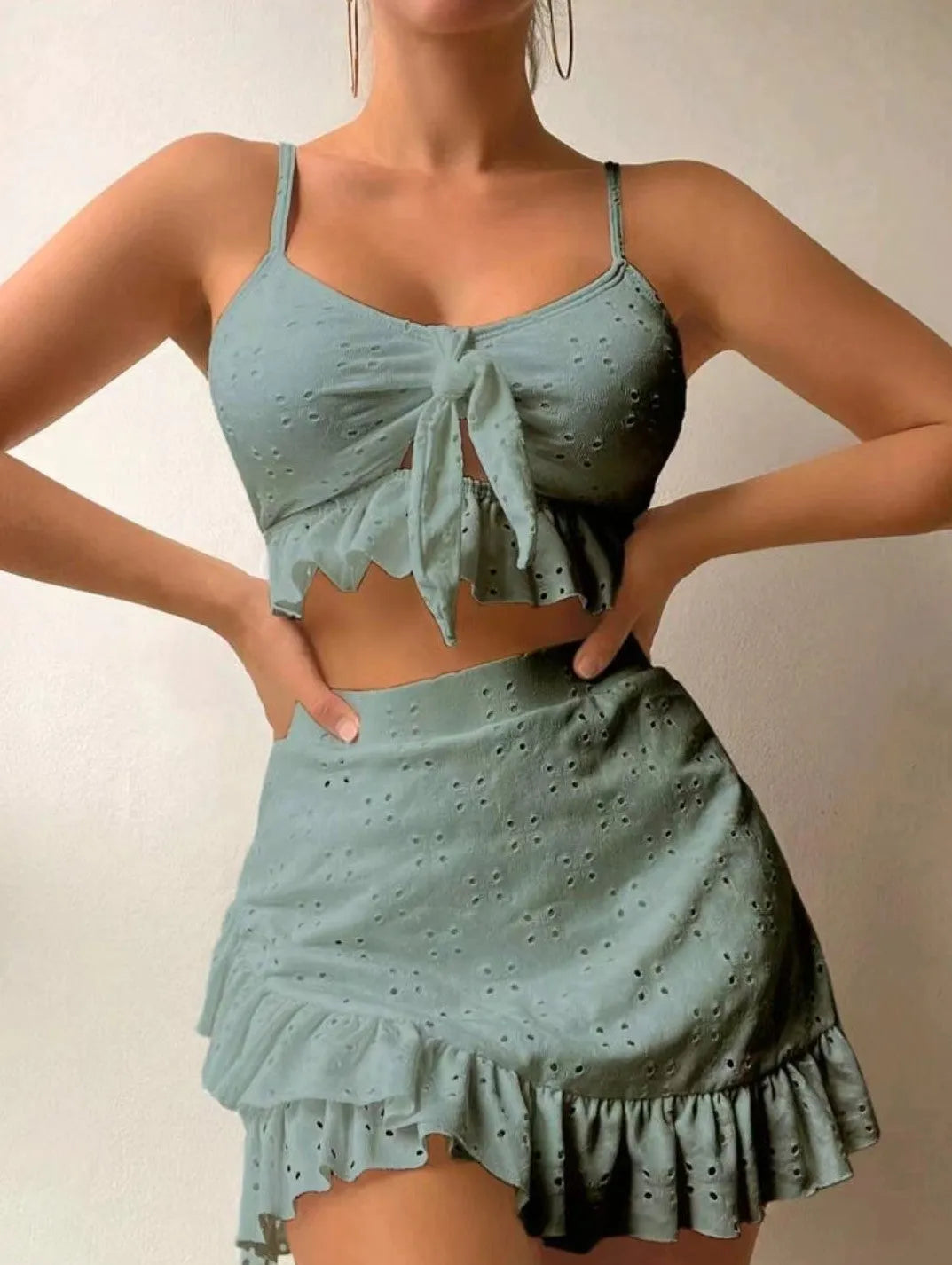 Women's solid colour three-piece bikini swimsuit with a split hip skirt.