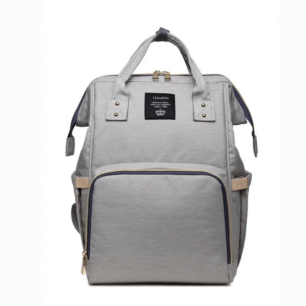 Stylish maternity diaper bag in various colors, featuring a paper bag design, separate bottle compartment, and discreet breastfeeding button.