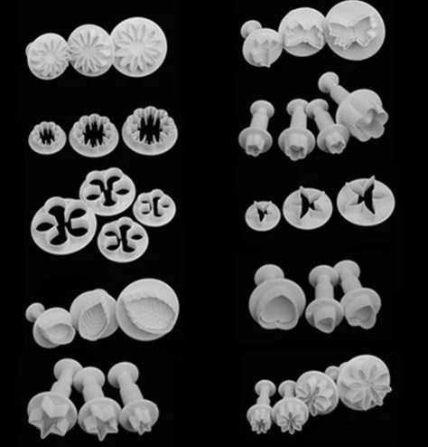 Assortment of cake decorating tools including plungers and knives in various floral designs