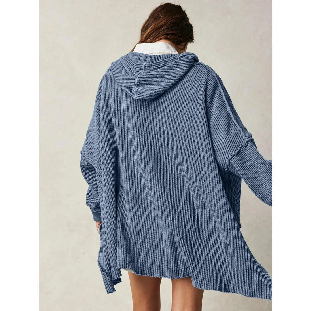 A cosy, oversized black hoodie with pockets, perfect for keeping warm during the autumn and winter seasons in the UK.