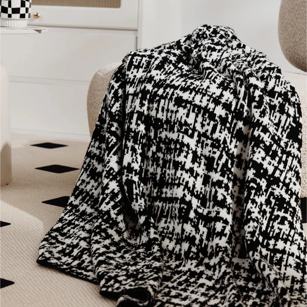 Cosy wearable wool blend travel blanket with timeless black and white striped pattern