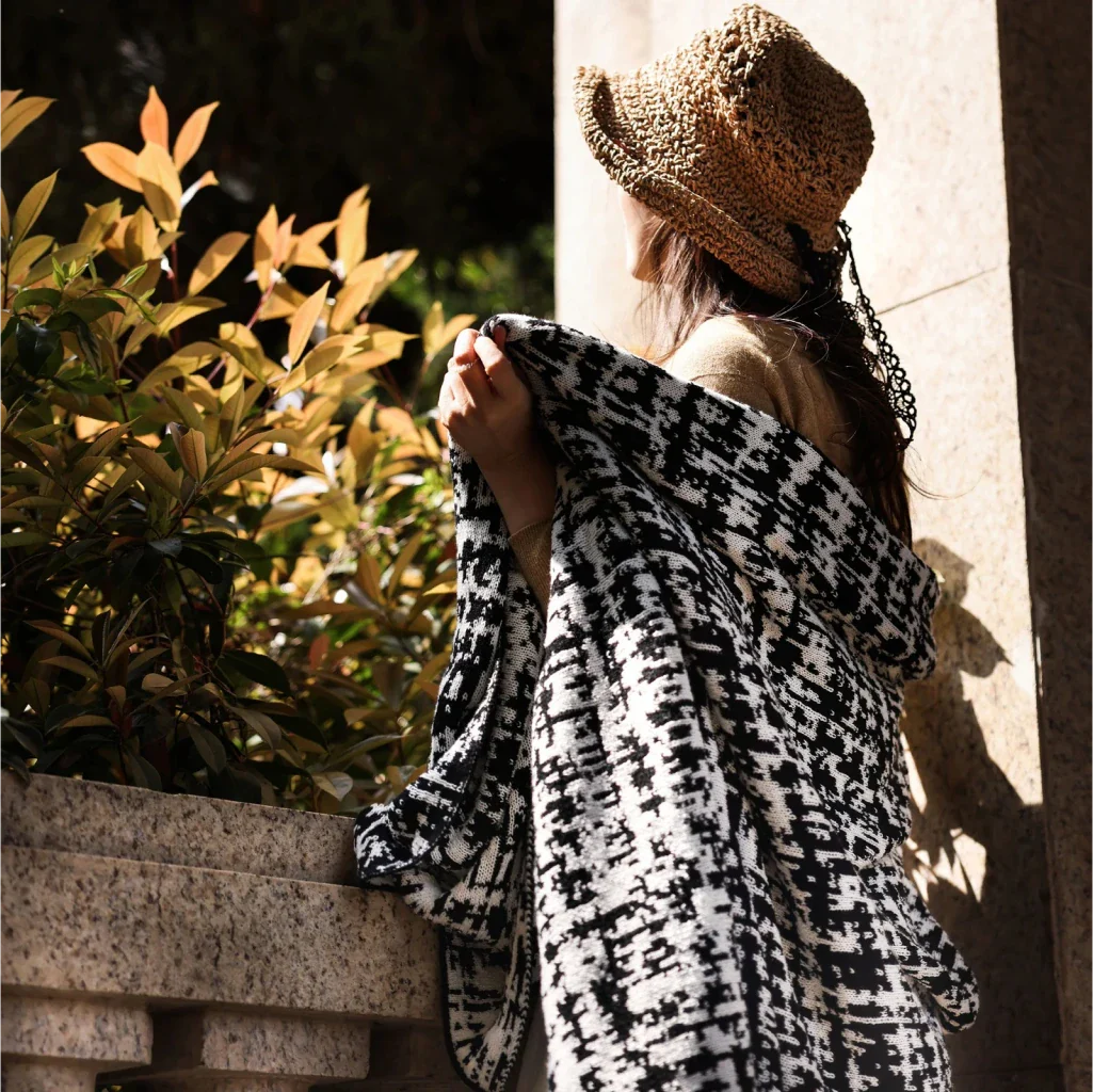 Cosy wearable wool blend travel blanket with timeless black and white striped pattern