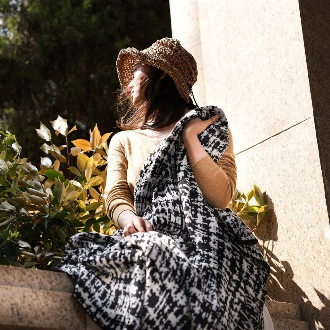 Cosy wearable wool blend travel blanket with timeless black and white striped pattern