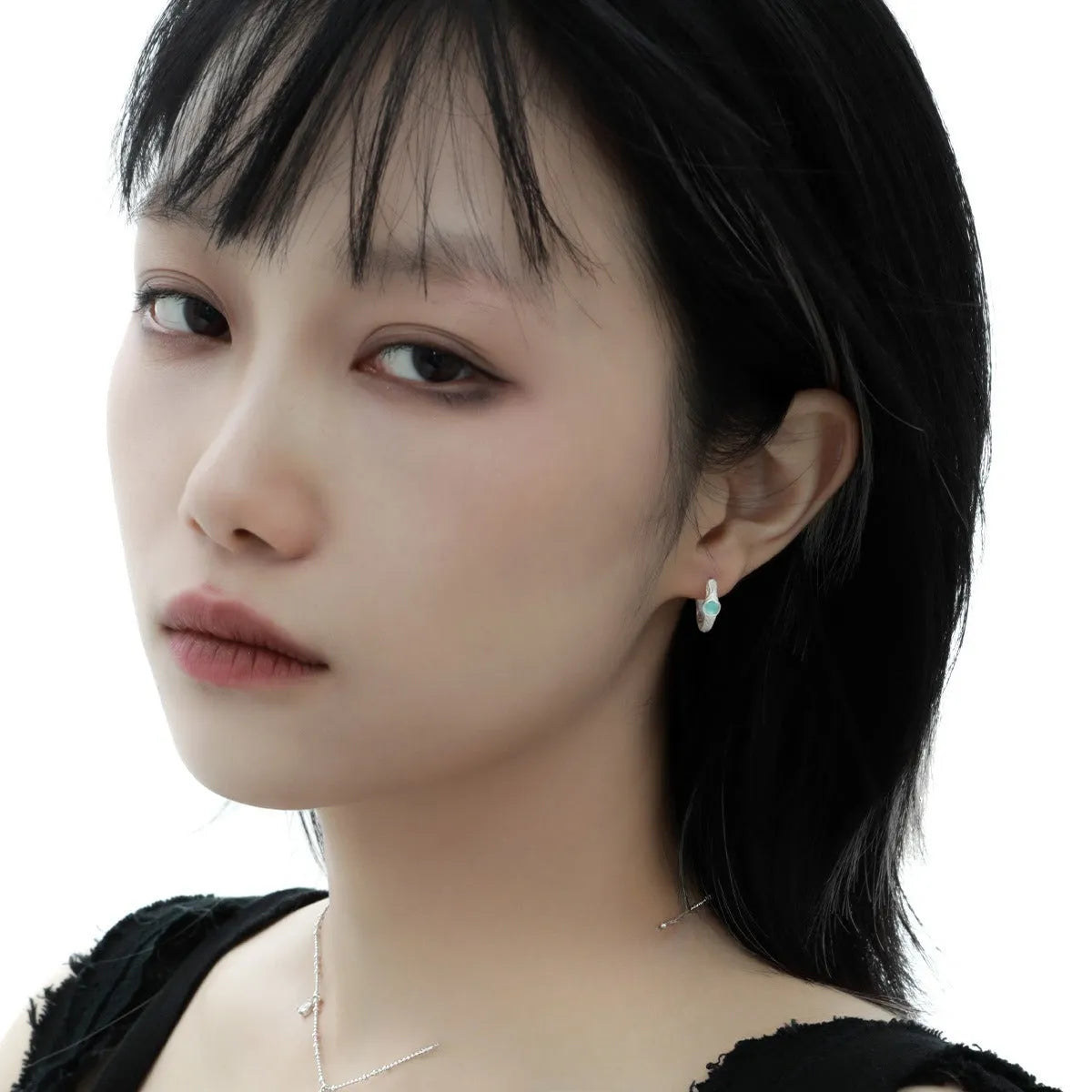 Geometric burnt silver sterling silver ear clip for women on a plain background.