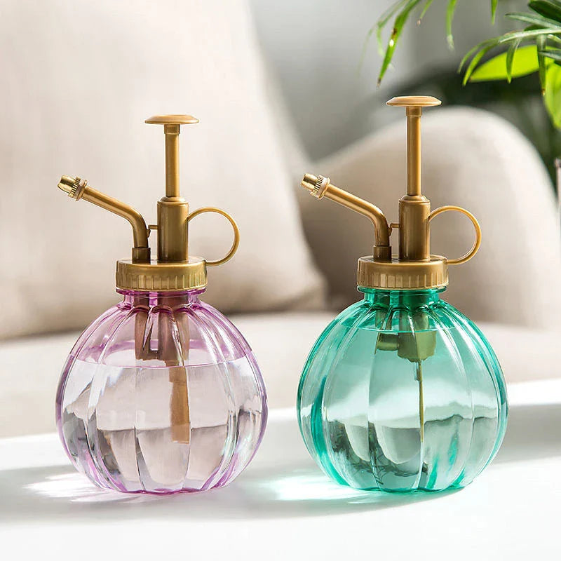 A stylish garden sprayer in a pumpkin shape with a retro-inspired copper pressure bar, designed for watering flowers and plants efficiently.