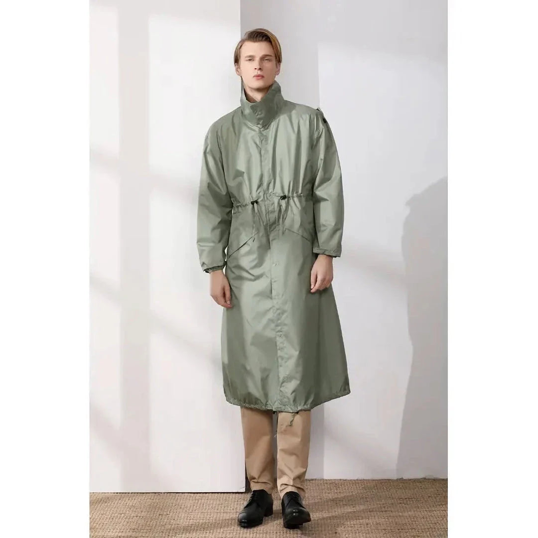 A man wearing a long, waterproof raincoat while enjoying an outdoor activity in the British countryside.