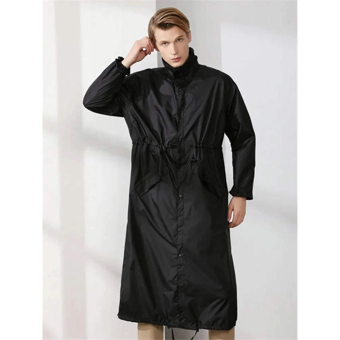 A man wearing a long, waterproof raincoat while enjoying an outdoor activity in the British countryside.