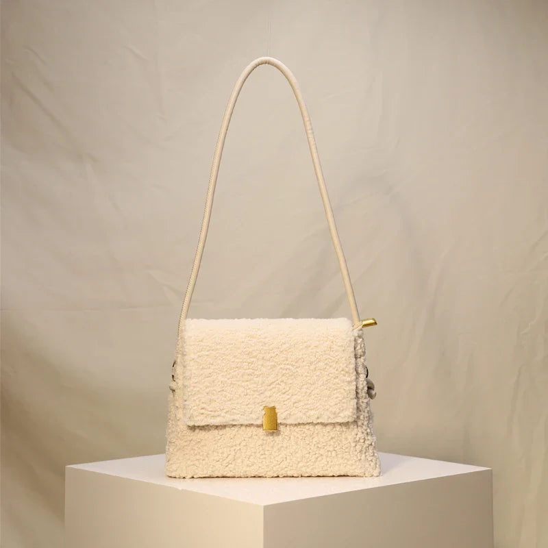 A stylish faux lamb wool crossbody bag in a neutral colour, featuring a double strap design and multiple interior compartments for organised storage.
