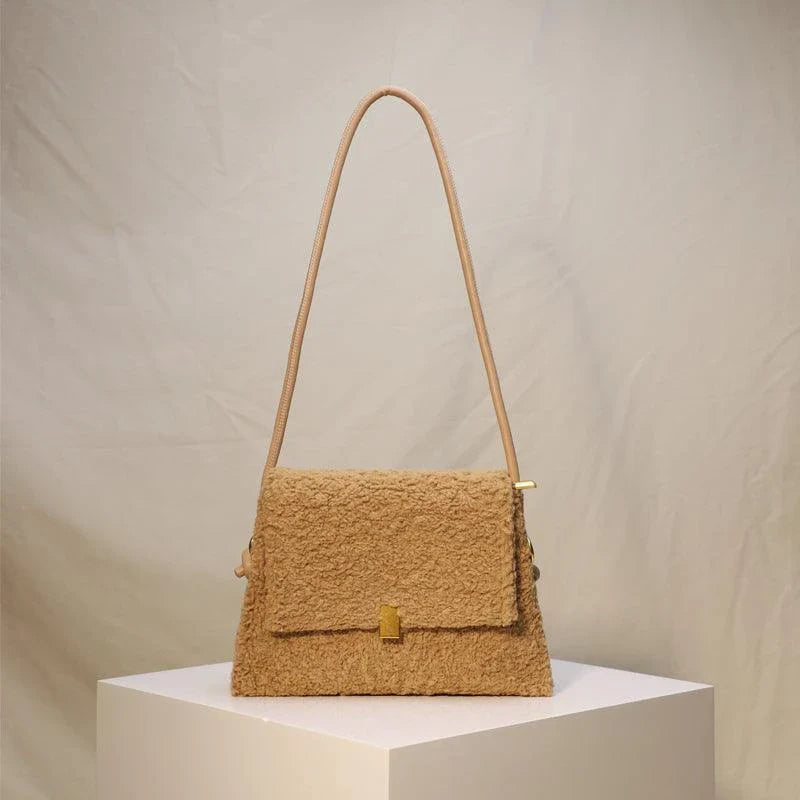 A stylish faux lamb wool crossbody bag in a neutral colour, featuring a double strap design and multiple interior compartments for organised storage.