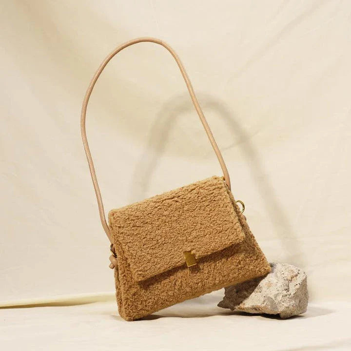 A stylish faux lamb wool crossbody bag in a neutral colour, featuring a double strap design and multiple interior compartments for organised storage.