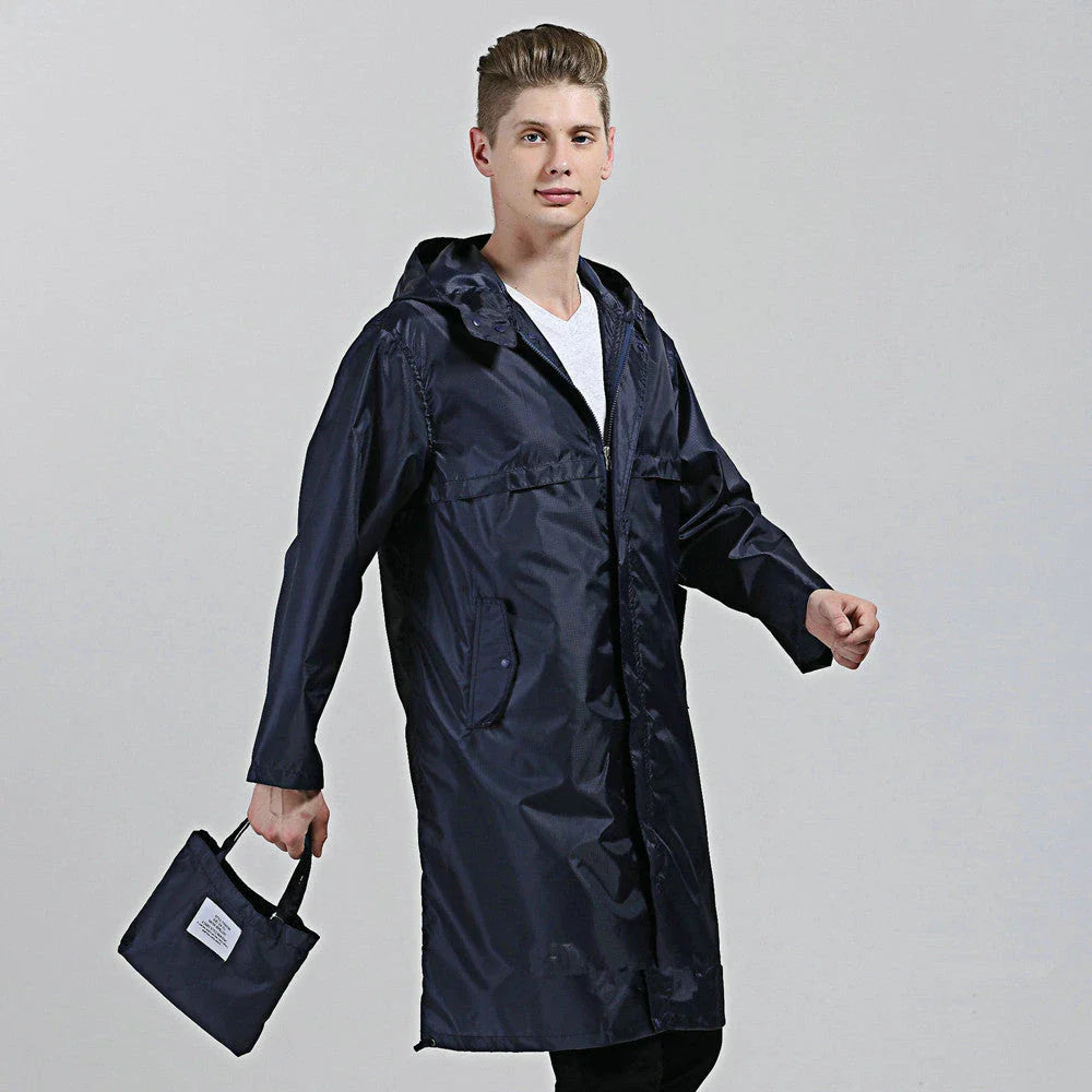 A man wearing a navy blue waterproof nylon raincoat standing in a field