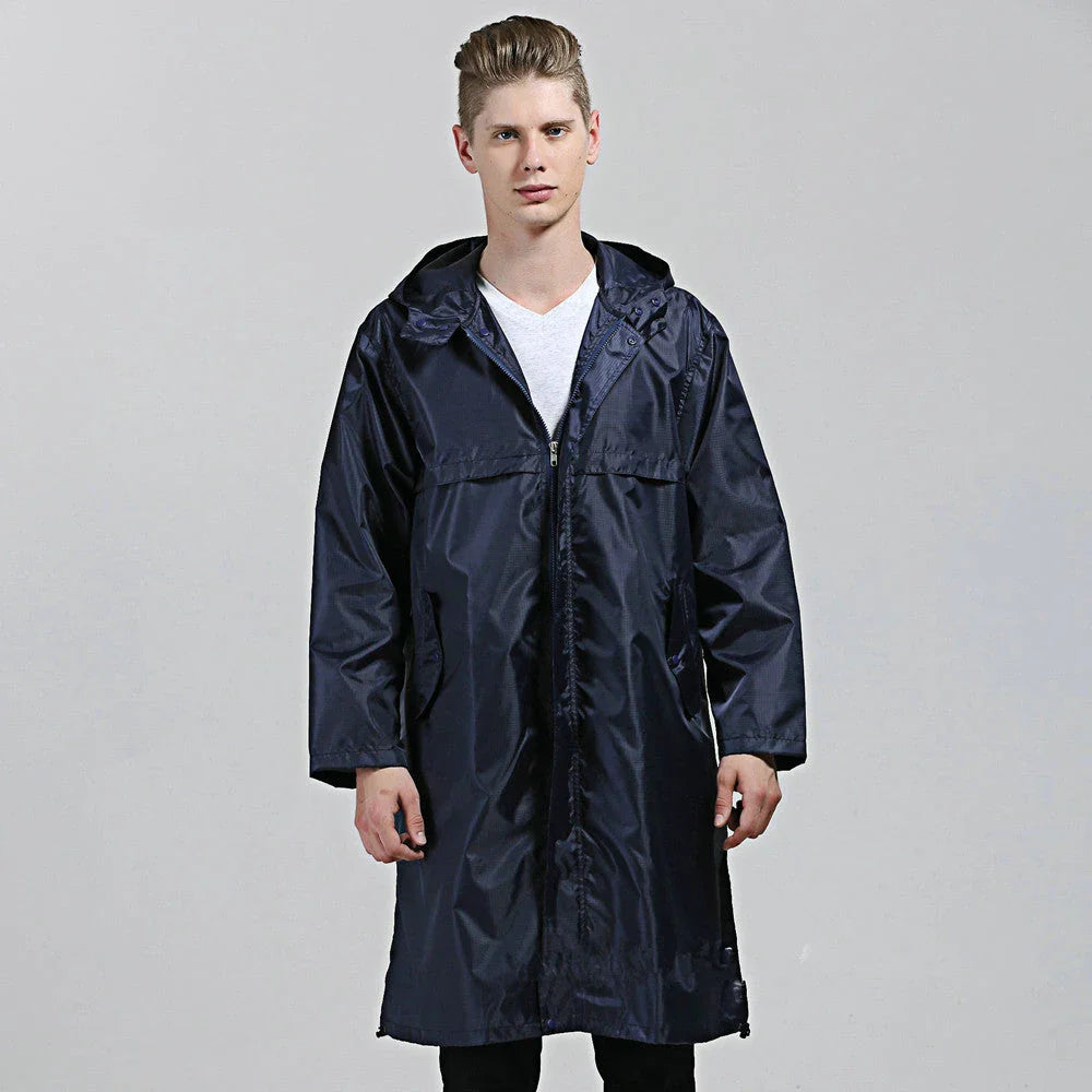 A man wearing a navy blue waterproof nylon raincoat standing in a field