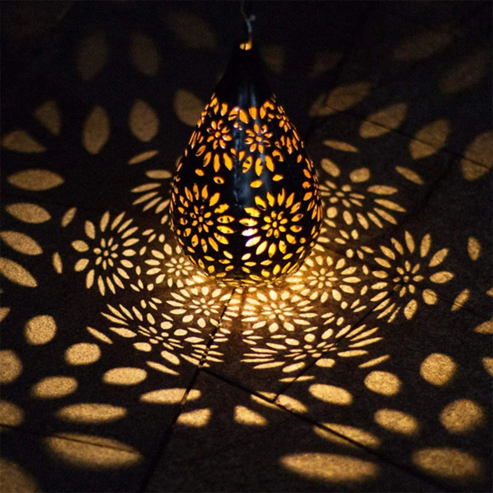 Elegant solar-powered garden lantern with a drop-shaped metal design and a soft, flower-patterned glow