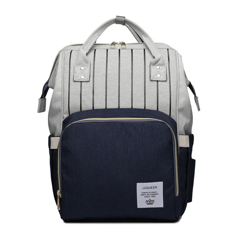 Stylish maternity diaper bag in various colors, featuring a paper bag design, separate bottle compartment, and discreet breastfeeding button.