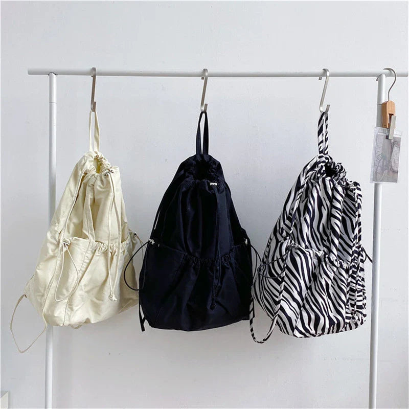 Creative drawstring bucket bag in white, black, brown, and zebra print patterns - a stylish and versatile women's tote bag made of high-quality polyester material