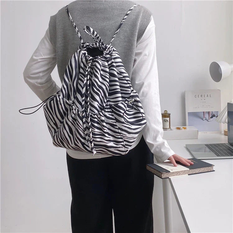 Creative drawstring bucket bag in white, black, brown, and zebra print patterns - a stylish and versatile women's tote bag made of high-quality polyester material
