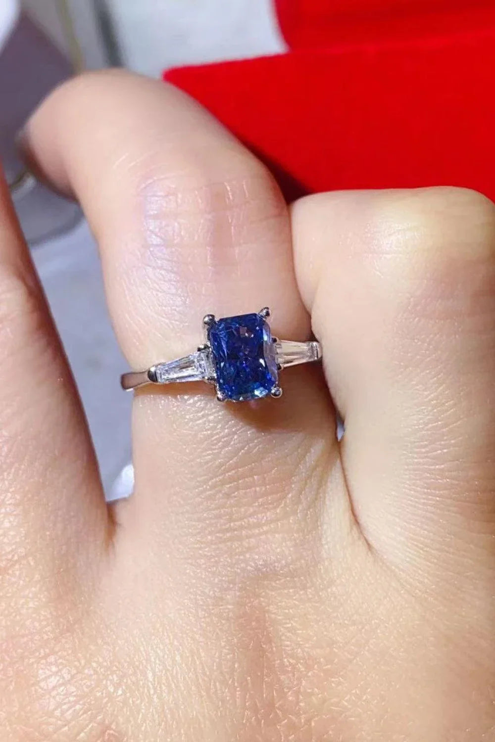 A shimmering 1 carat moissanite ring in a platinum-plated setting with a rectangular shape and sparkling accent stones
