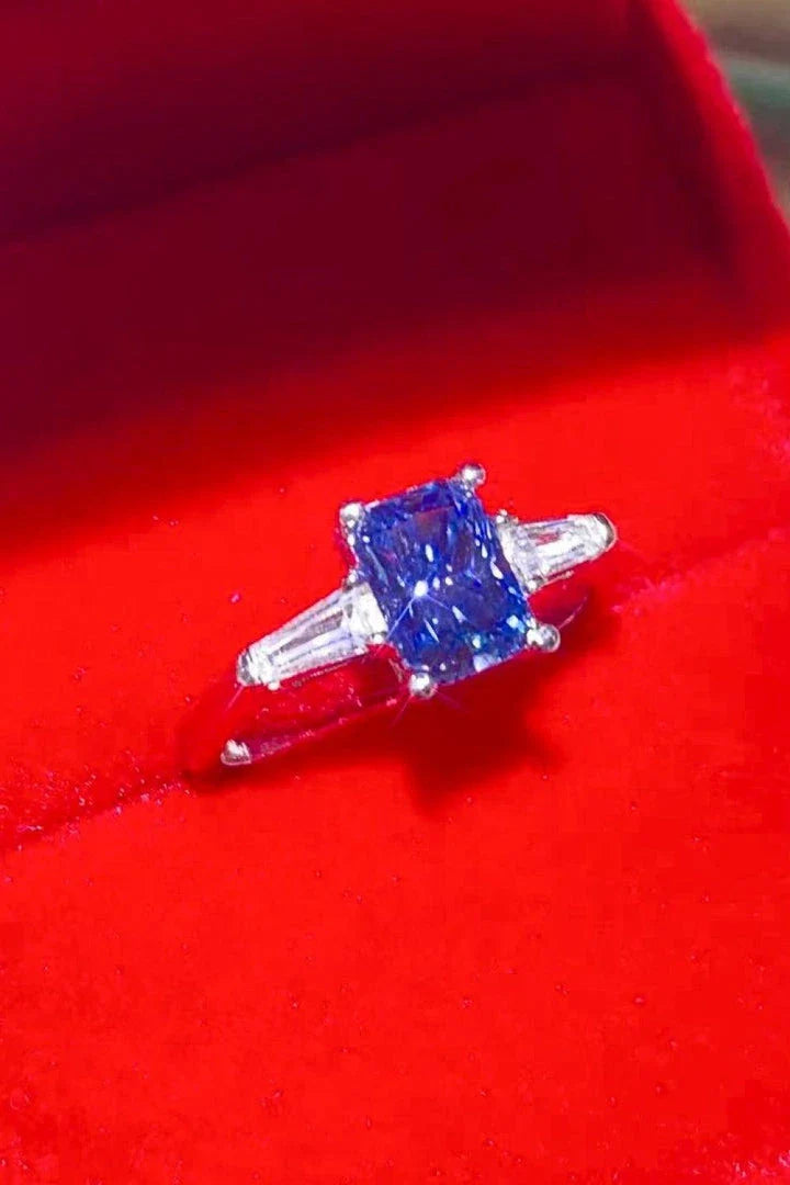 A shimmering 1 carat moissanite ring in a platinum-plated setting with a rectangular shape and sparkling accent stones