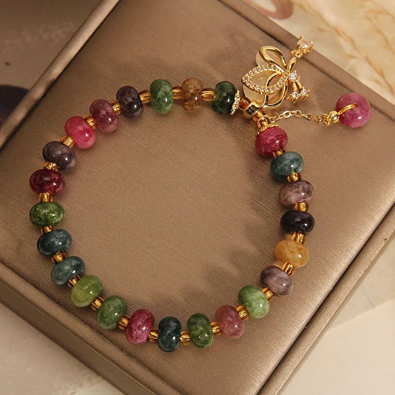 Close-up of a women's colourful butterfly bracelet with alloy construction, colourful beads, and tourmaline details.