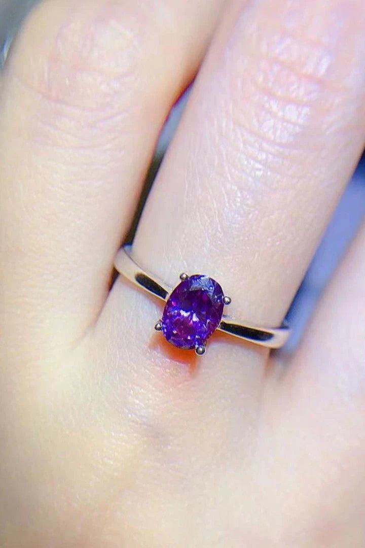 A sparkling 1 carat moissanite stone set in a 925 sterling silver 4-prong solitaire ring with a platinum-plated finish.
