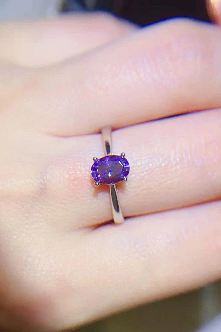 A sparkling 1 carat moissanite stone set in a 925 sterling silver 4-prong solitaire ring with a platinum-plated finish.