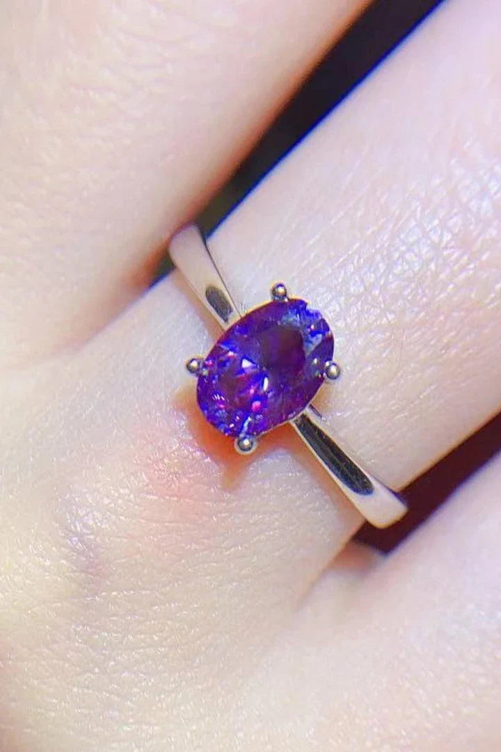 A sparkling 1 carat moissanite stone set in a 925 sterling silver 4-prong solitaire ring with a platinum-plated finish.