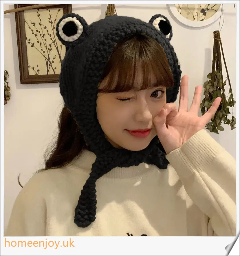 A cosy and stylish woollen hat featuring a charming cartoon frog design with big, expressive eyes