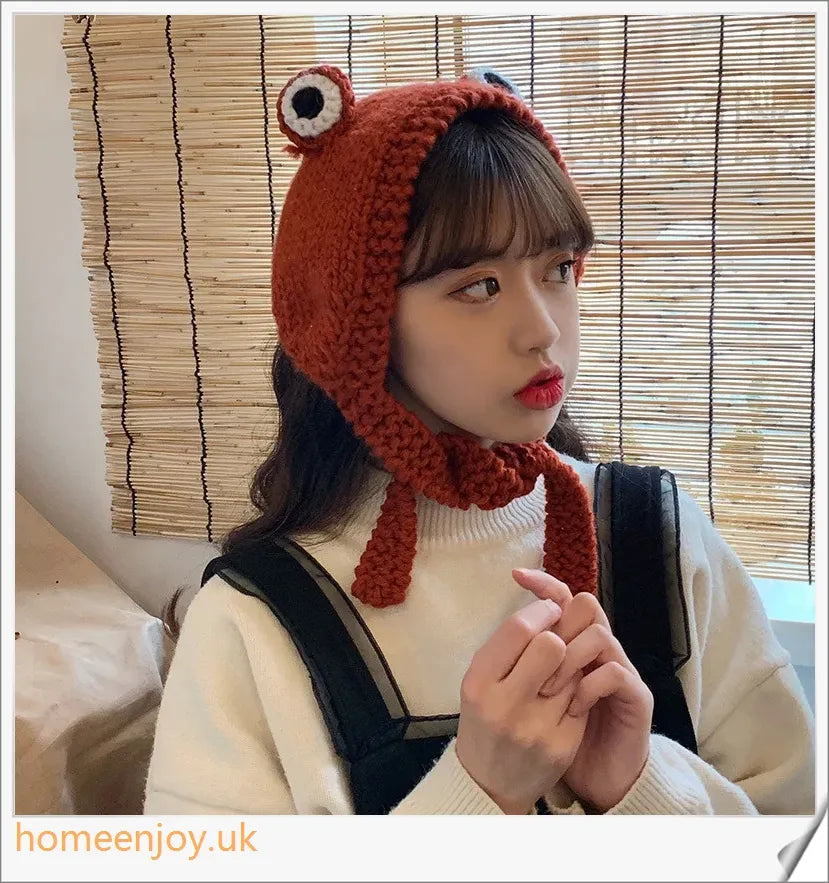 A cosy and stylish woollen hat featuring a charming cartoon frog design with big, expressive eyes
