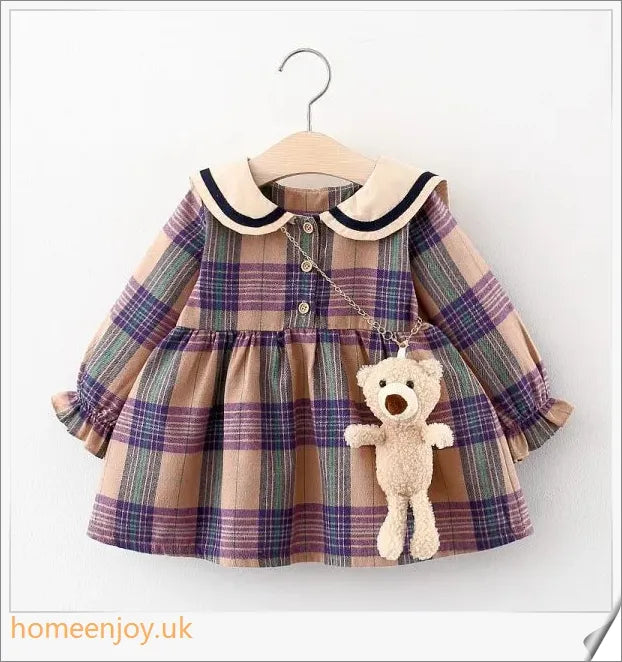 Baby girl wearing a long-sleeve dress with a grid pattern in purple and khaki colours