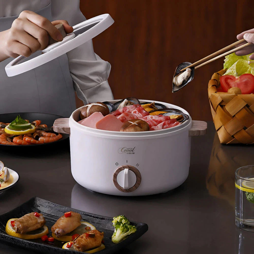 Multifunction Mini Electric Cooking Pot with Food Steamer - A compact and versatile kitchen appliance with non-stick surface and steamer attachment.
