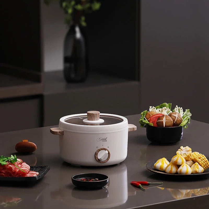 Multifunction Mini Electric Cooking Pot with Food Steamer - A compact and versatile kitchen appliance with non-stick surface and steamer attachment.