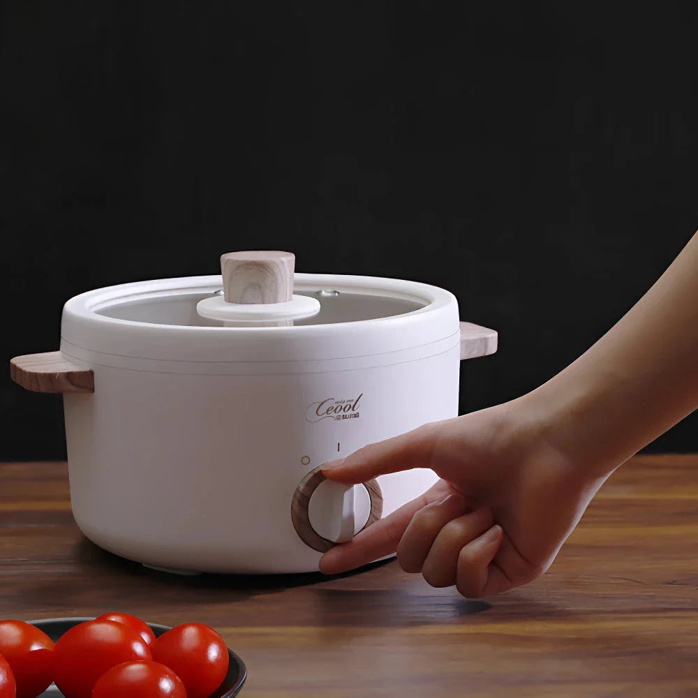 Multifunction Mini Electric Cooking Pot with Food Steamer - A compact and versatile kitchen appliance with non-stick surface and steamer attachment.