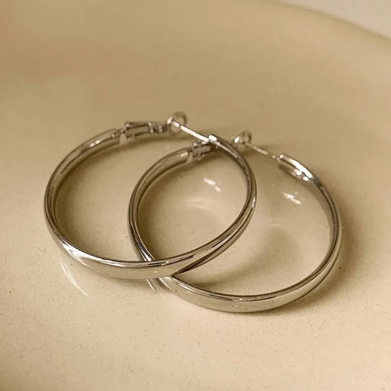A pair of large, circular metal earrings in gold or silver colour, measuring 40mm.