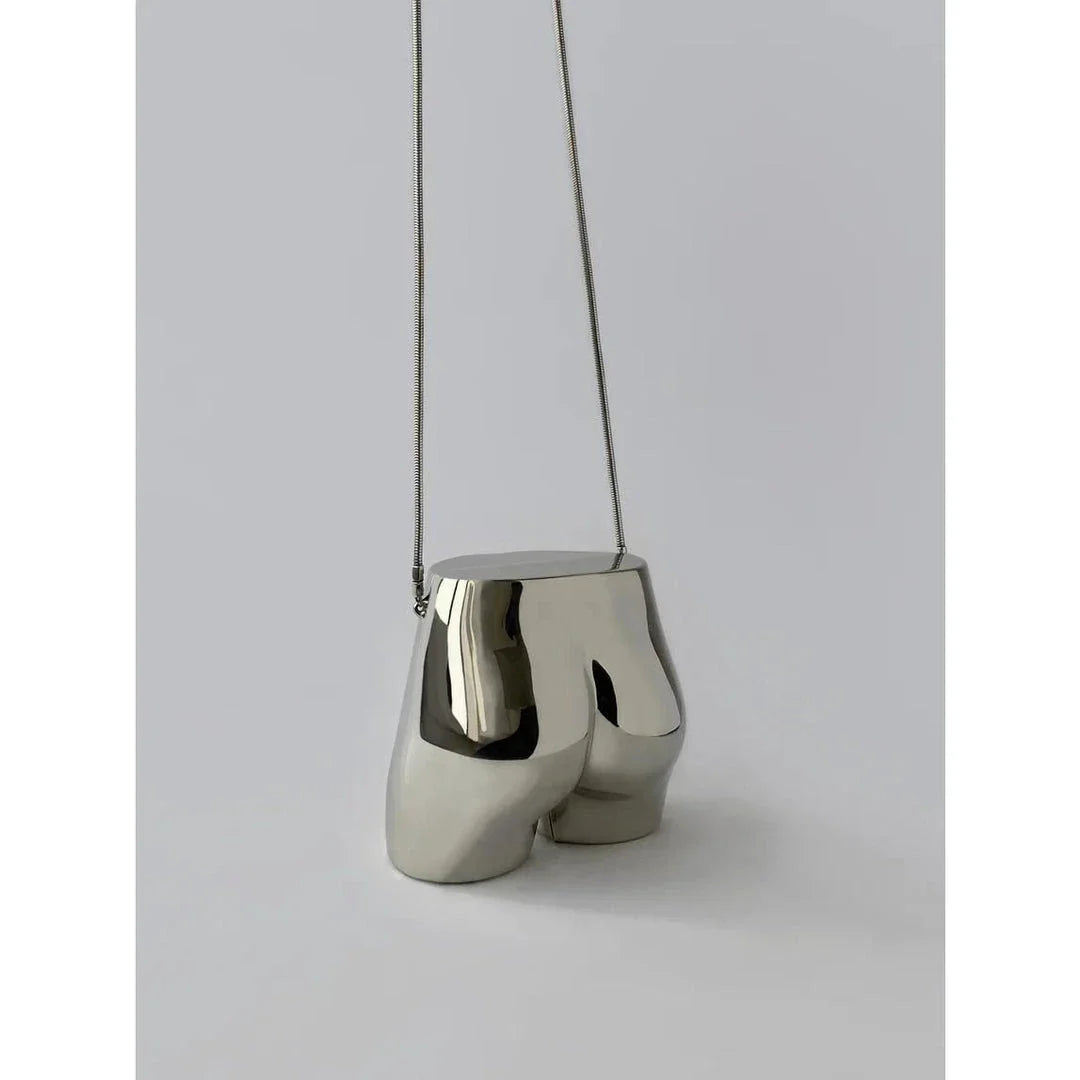 A sleek and sophisticated acrylic crossbody bag in a striking silver colour, perfect for formal events and evening occasions.