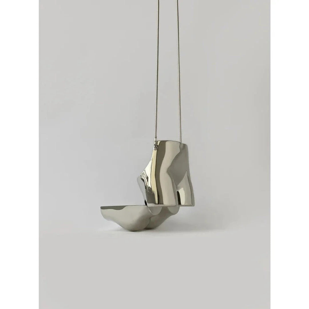 A sleek and sophisticated acrylic crossbody bag in a striking silver colour, perfect for formal events and evening occasions.