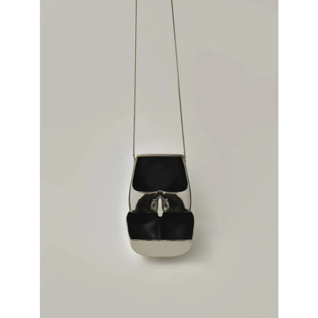 A sleek and sophisticated acrylic crossbody bag in a striking silver colour, perfect for formal events and evening occasions.