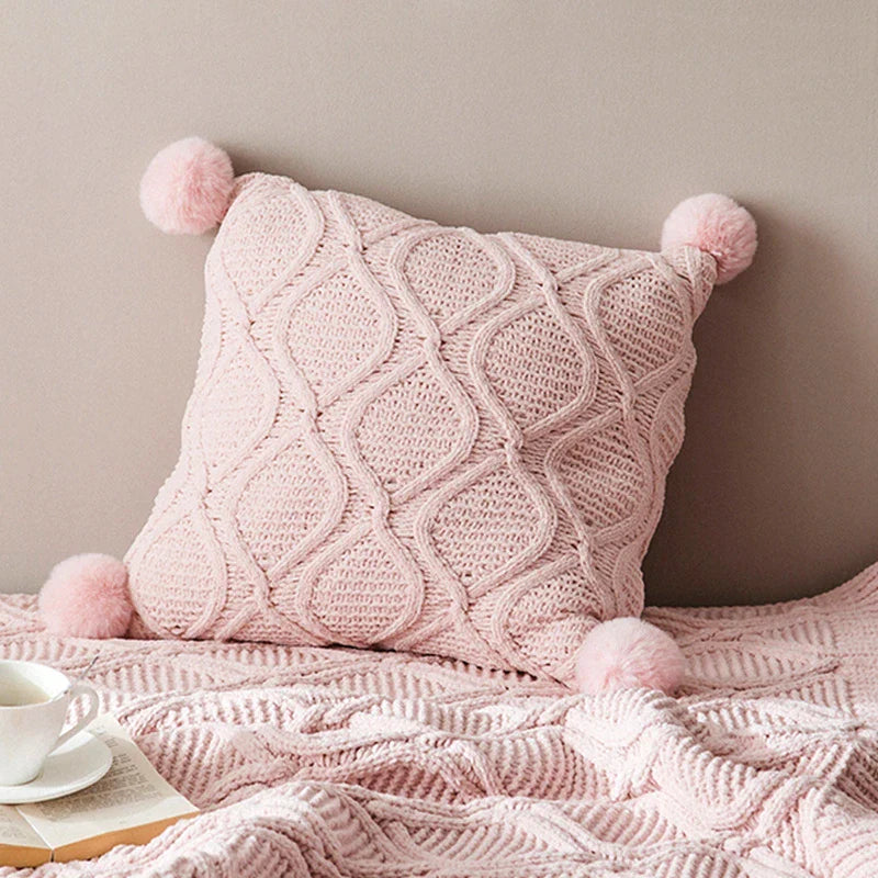 A cosy, knitted Nordic-inspired wind ball pillow in a neutral white colour, perfect for adding a touch of Scandinavian style to your living room decor.