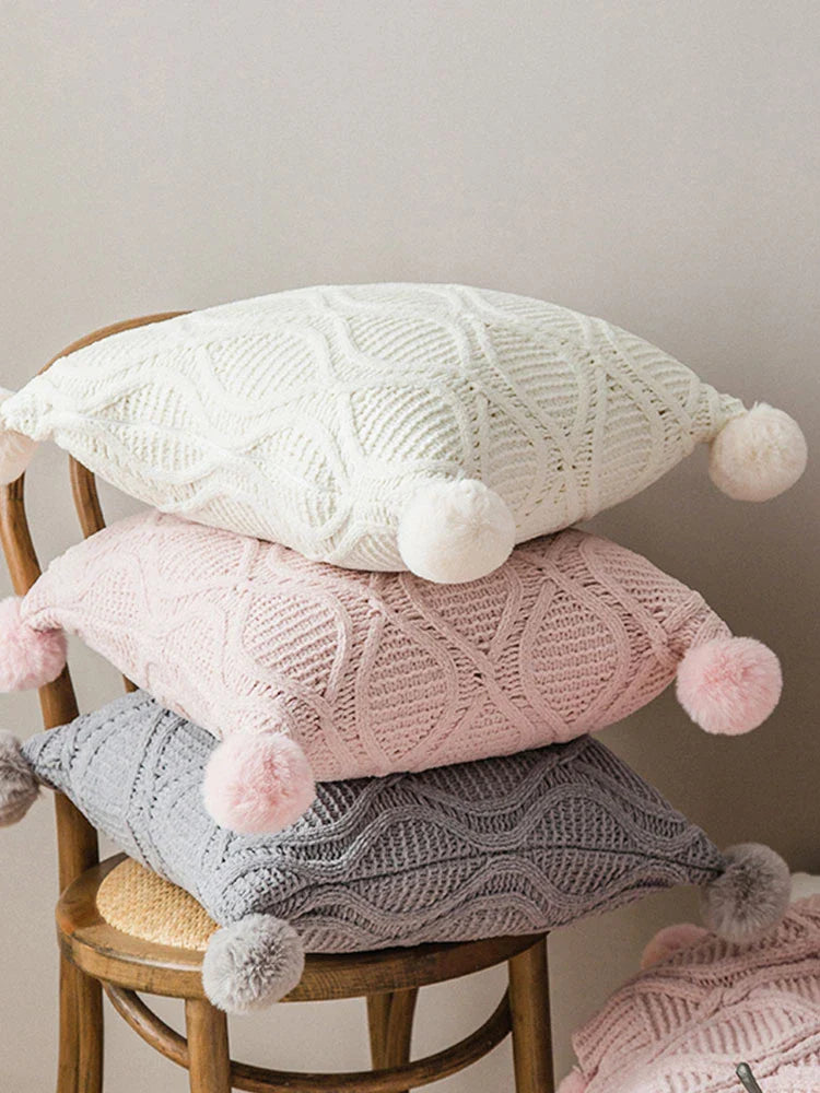 A cosy, knitted Nordic-inspired wind ball pillow in a neutral white colour, perfect for adding a touch of Scandinavian style to your living room decor.