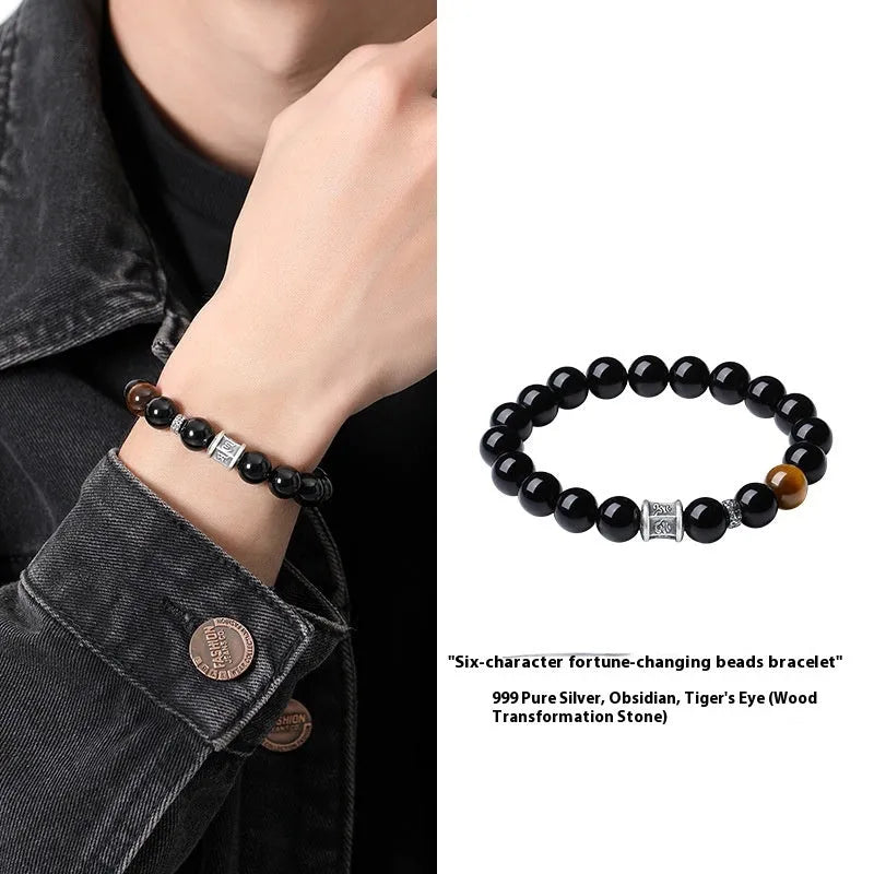 Men's black obsidian bracelet with 10mm prayer wheel beads and silver accents showing hand-woven construction