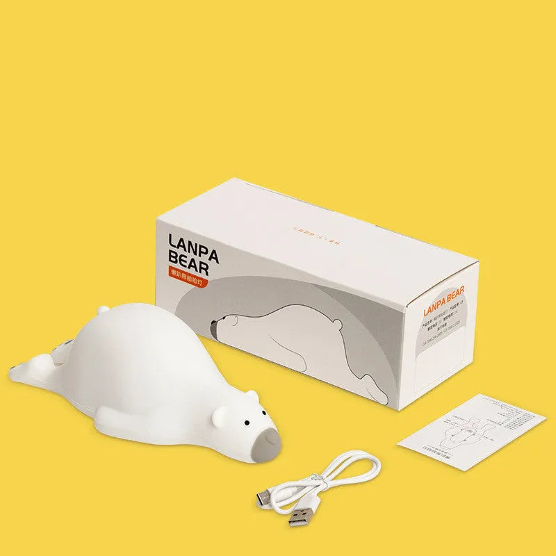 White bear-shaped silicone night light on a table with USB cable.