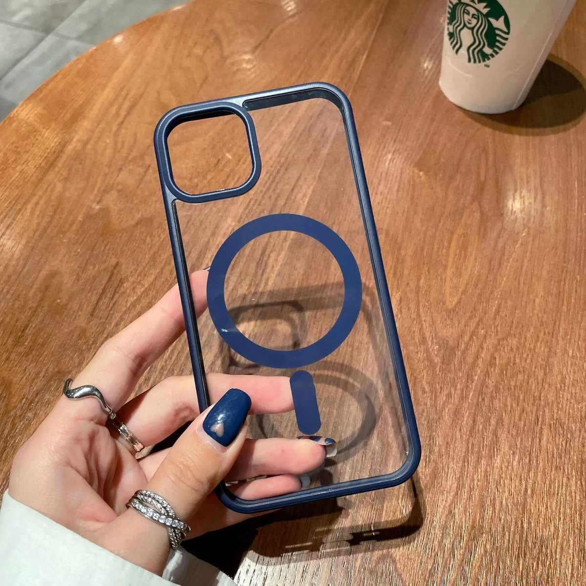 Clear acrylic MagSafe phone case for iPhone showing magnetic ring, displayed in pink, blue, white, black, and navy blue colour options.