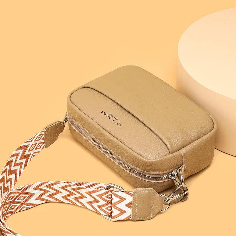 Stylish crossbody bag with rhombus embroidery, wide adjustable shoulder strap, and multiple interior pockets in various color options
