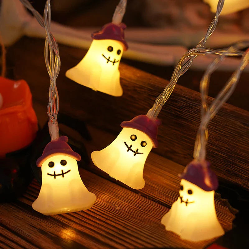 Battery-powered LED Halloween lights in various spooky designs including pumpkins, ghosts, and bats with warm white glow