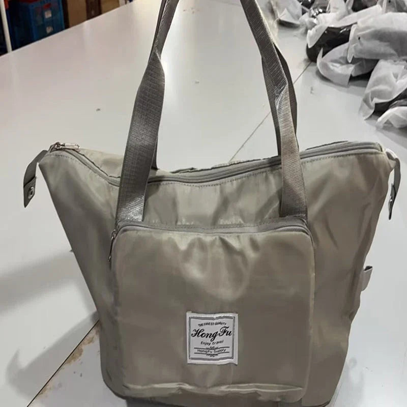 Stylish and spacious foldable travel bag for women, featuring a water-resistant Oxford cloth construction, multiple pockets, and convenient carrying options.