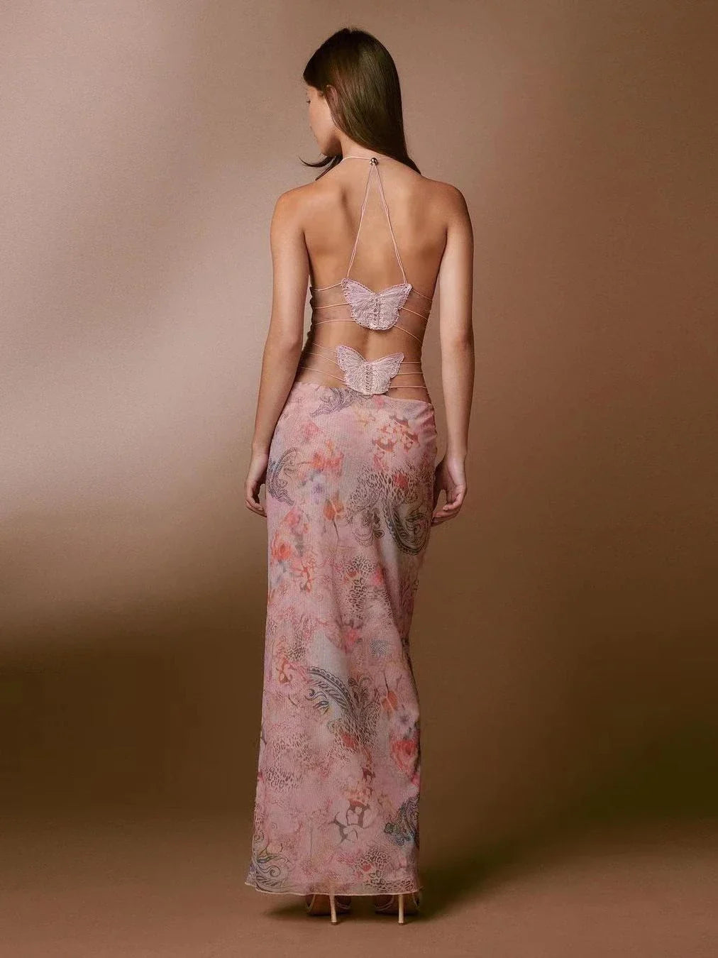 A stylish halter dress with a floral print and butterfly-inspired back, perfect for summer events and parties.