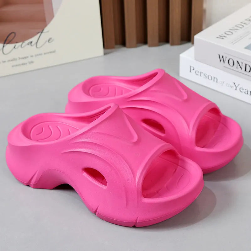 Women's white thick-soled EVA slippers with a round toe on a beach background.
