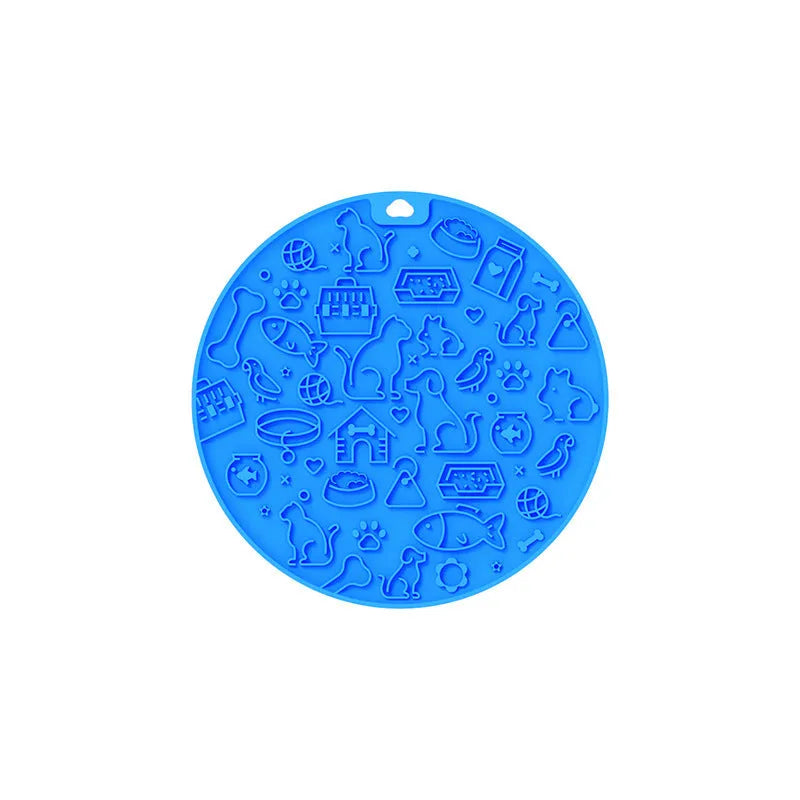 Round blue silicone pet licking mat with textured surface and a clear central suction cup, shown on a tile floor.