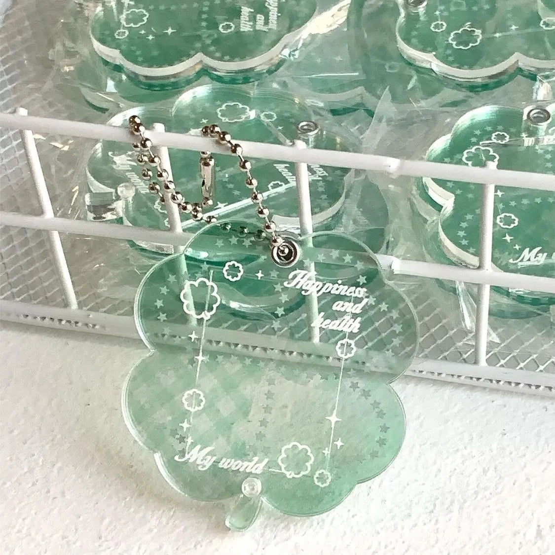 Four-leaf clover shaped acrylic phone pendant keychain in blue, green, and mint colour options